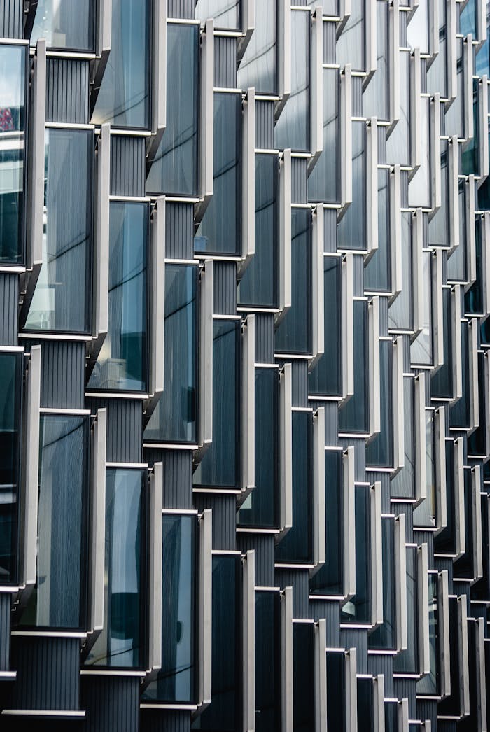 Services-02 Close-up view of a modern glass and metal building facade showcasing unique geometric patterns in London.