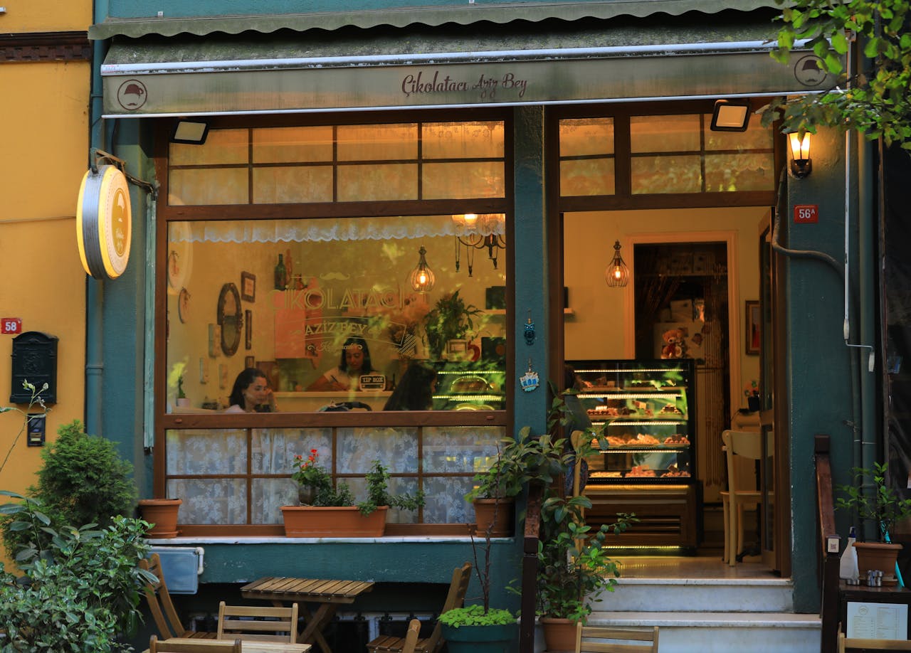 Inviting sidewalk café in İstanbul with warm lighting and cozy interior view.